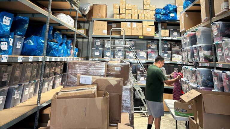 Volunteer sorting clothing donations at Project Ropa's warehouse.